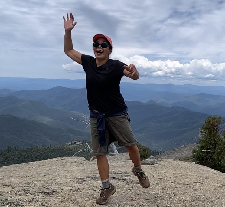 Nova, founder of MindTonic, celebrating on a mountain summit — clinical hypnotherapist Melbourne, Australia